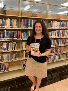 Kaci Boutwell, Director of The Flomaton Public Library in Flomaton, Alabama holds a copy of Ed Hudson's book.