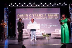 Steven G presents Dorothy Gurowitz scholarship check to Makaela Odom as Embrace Girls Foundation Founder and CEO Velma Clark looks on.